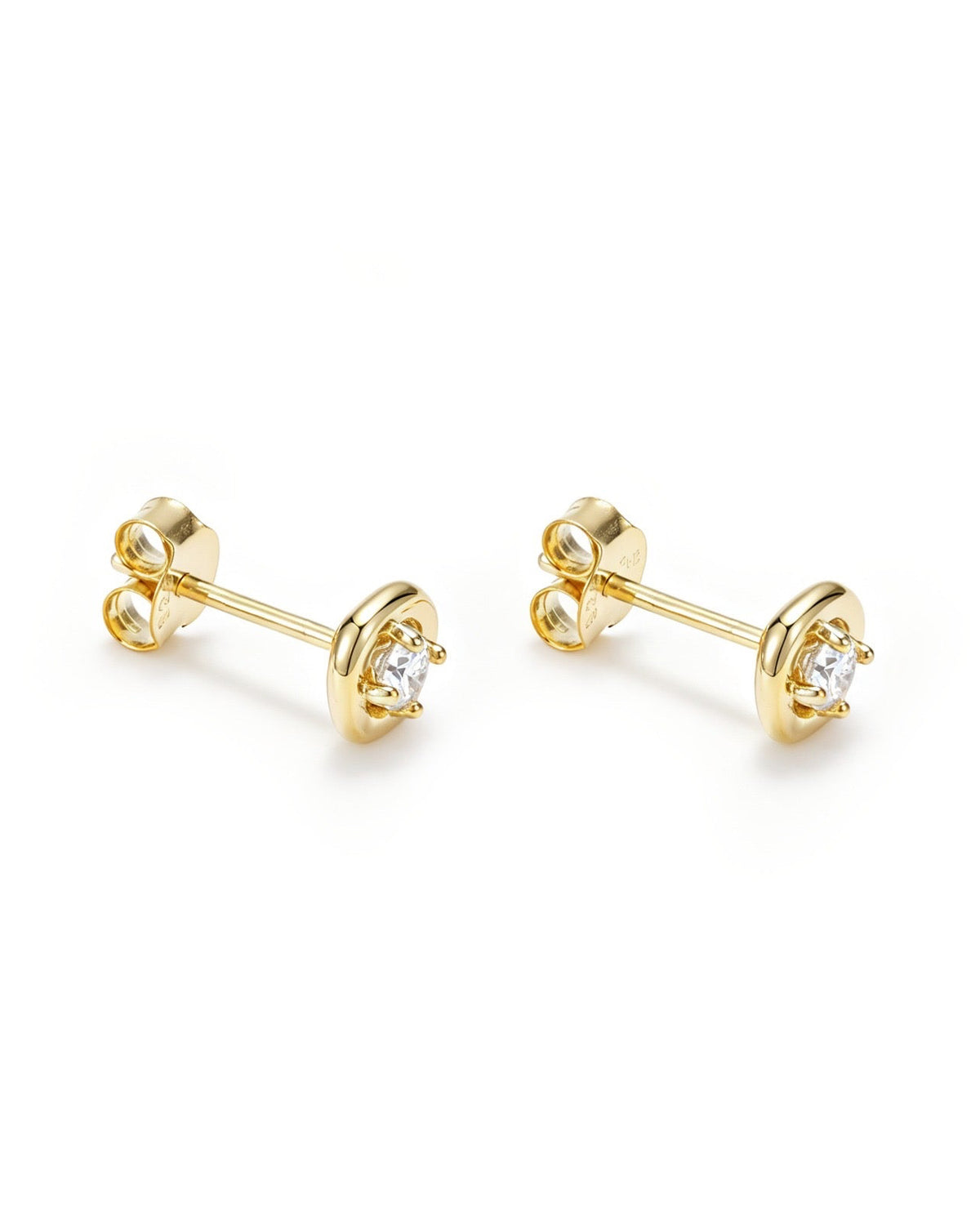 A pair of gold stud earrings with a circular bezel setting holding a clear round gemstone, shown on a clean white background.