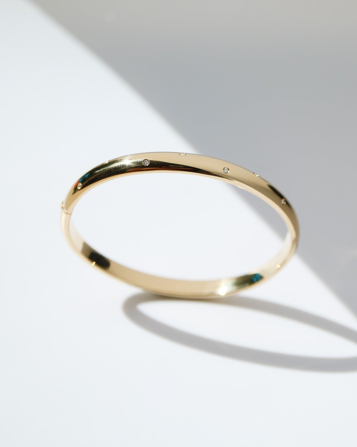 Gold bracelet on a light gray background
