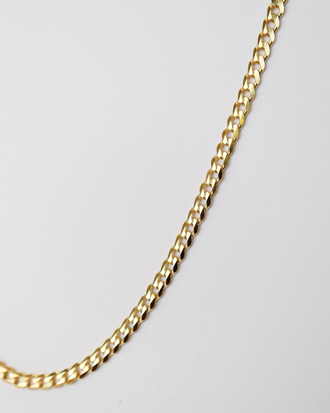 9kt solid gold Flat Curb Chain necklace featuring polished, flattened interlocking links, photographed on a white background close up