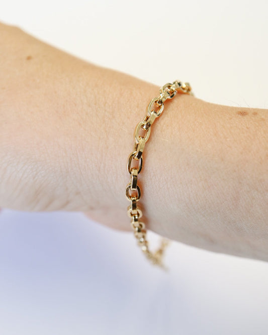 9kt solid gold Paperclip Cable Bracelet worn on the wrist, featuring polished elongated links and a modern gold chain design.