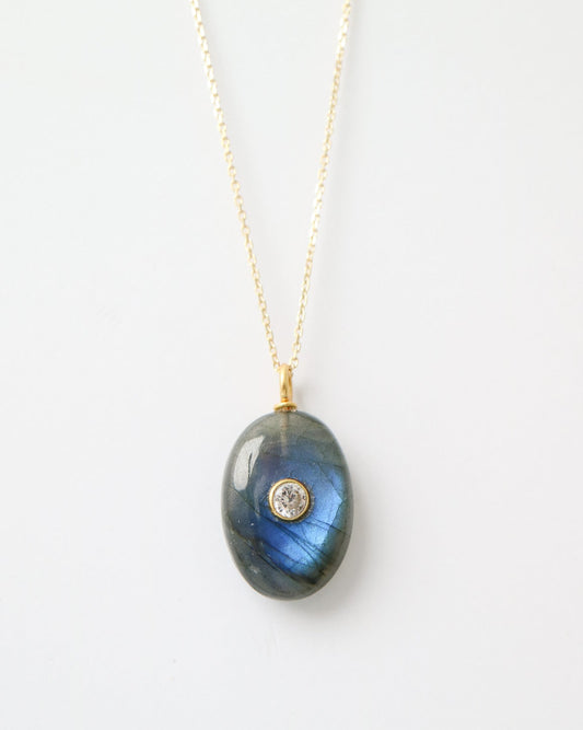 Eclipse Labradorite Pendant featuring a polished oval labradorite gemstone with natural blue flashes, a bezel-set cubic zirconia, and a gold plated sterling silver bail on a white background.