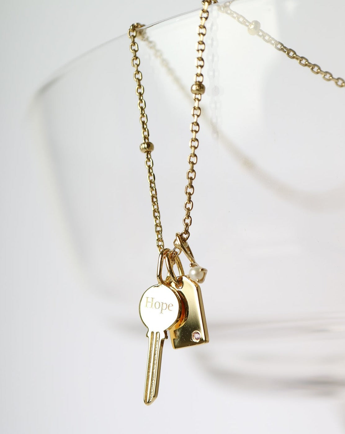 Gold Charm Necklace with key, pearl, gemstone tag