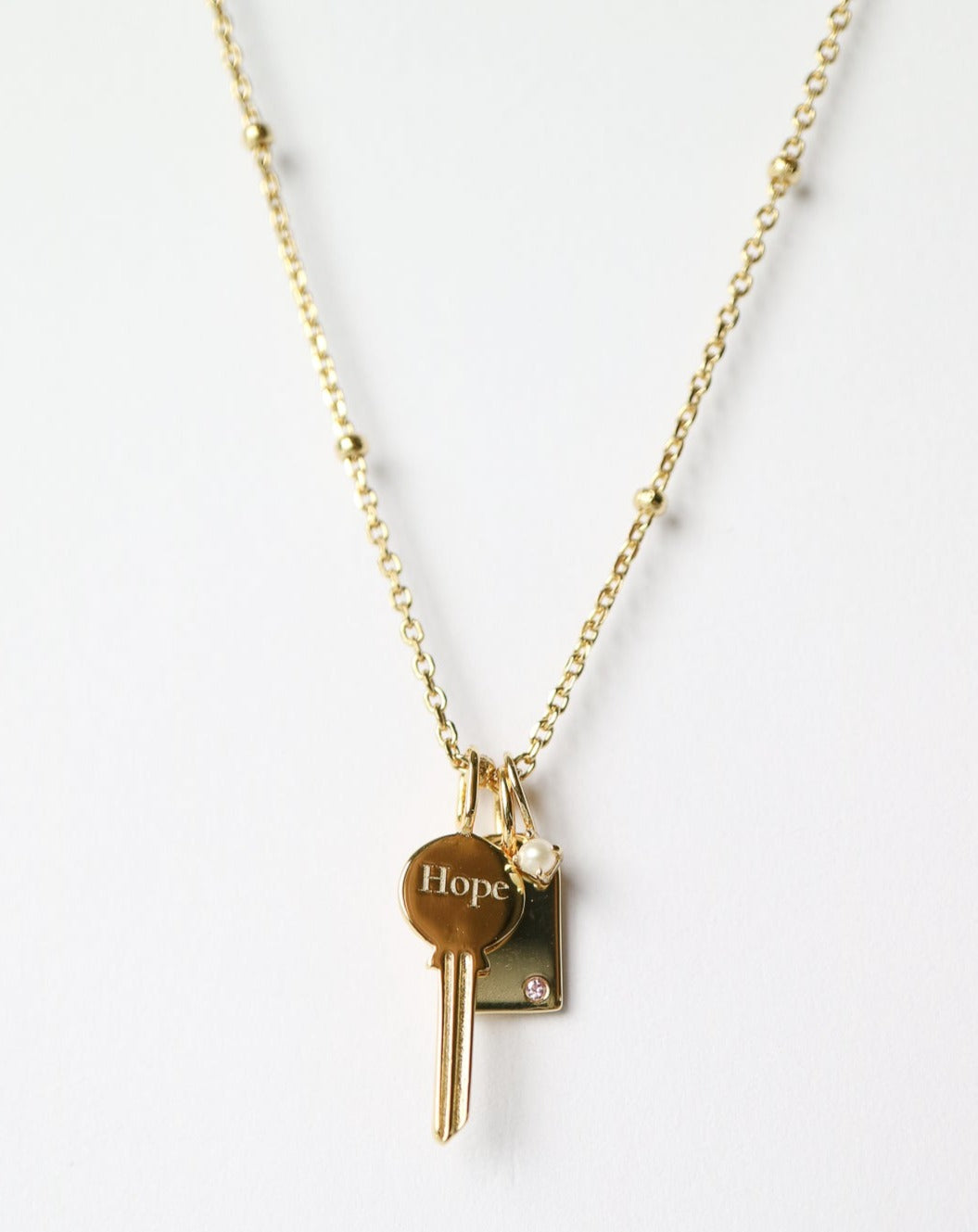 Gold Charm Necklace with key, pearl, gemstone tag
