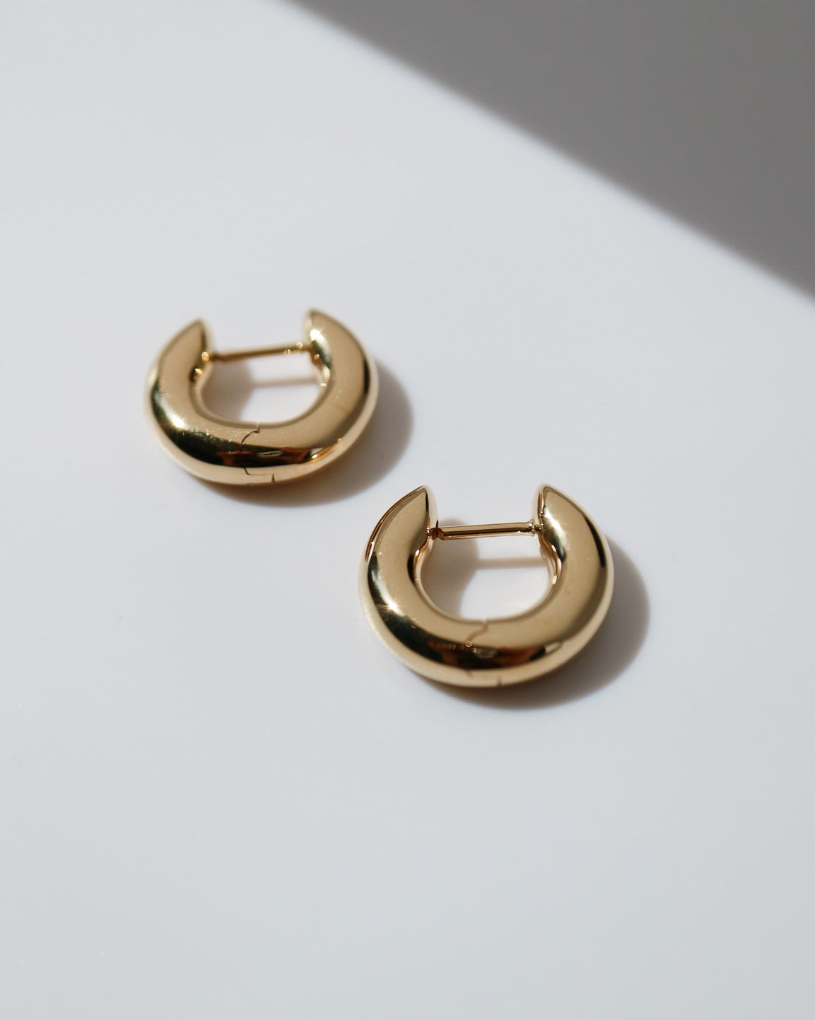 Gold hoop earrings on a light gray background