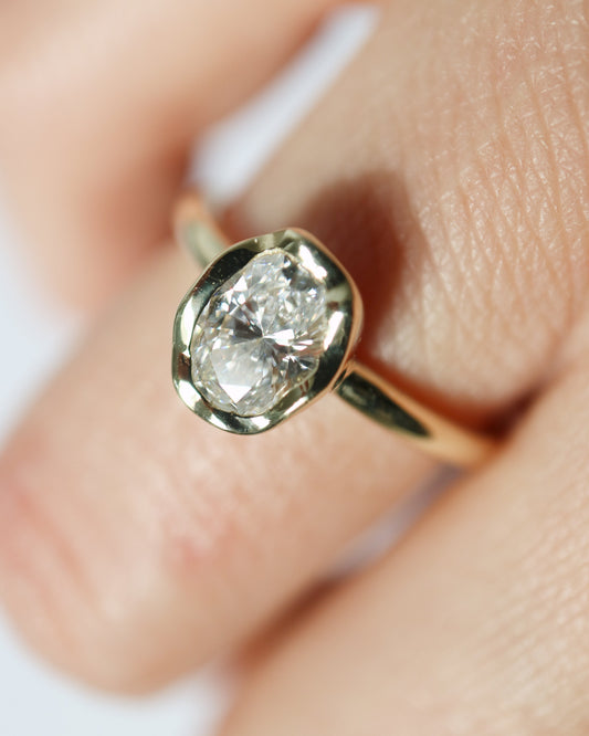 9ct Gold ring with a diamond on a finger against a white background