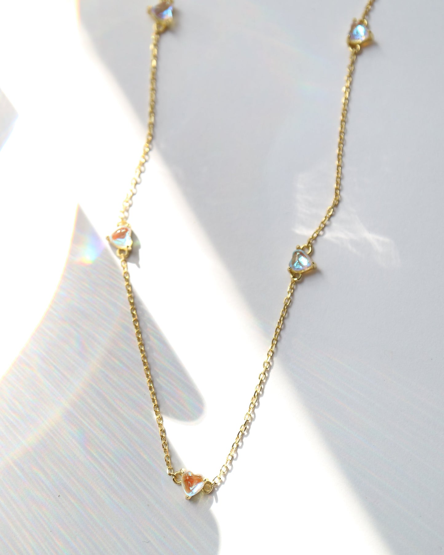 Gold necklace with small diamonds on a white background
