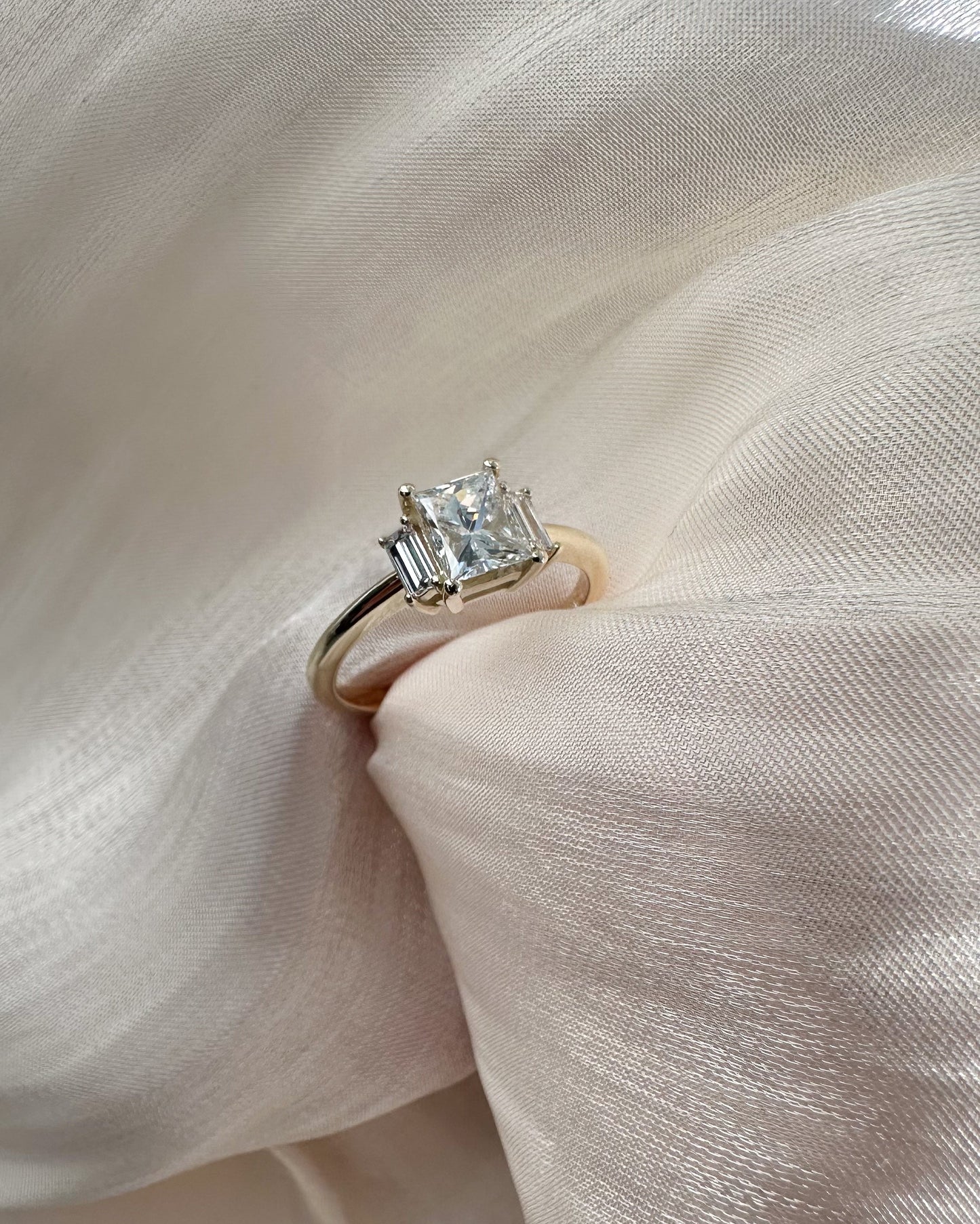 Diamond ring on a soft pink fabric background