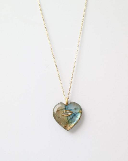 Heart-shaped gemstone pendant on a gold chain against a white background