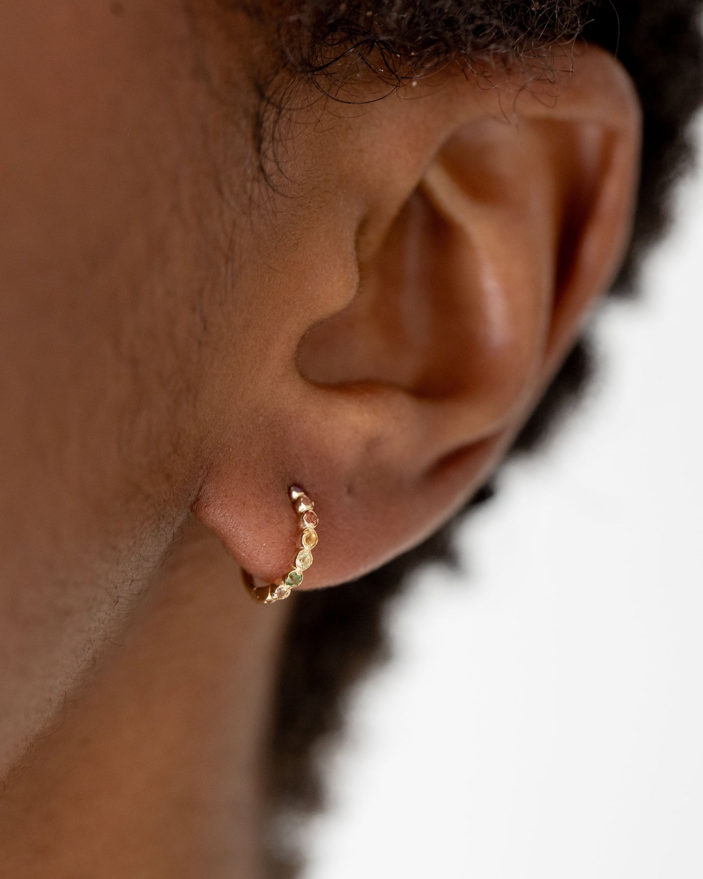 9kt gold Rainbow Huggie Earrings on model