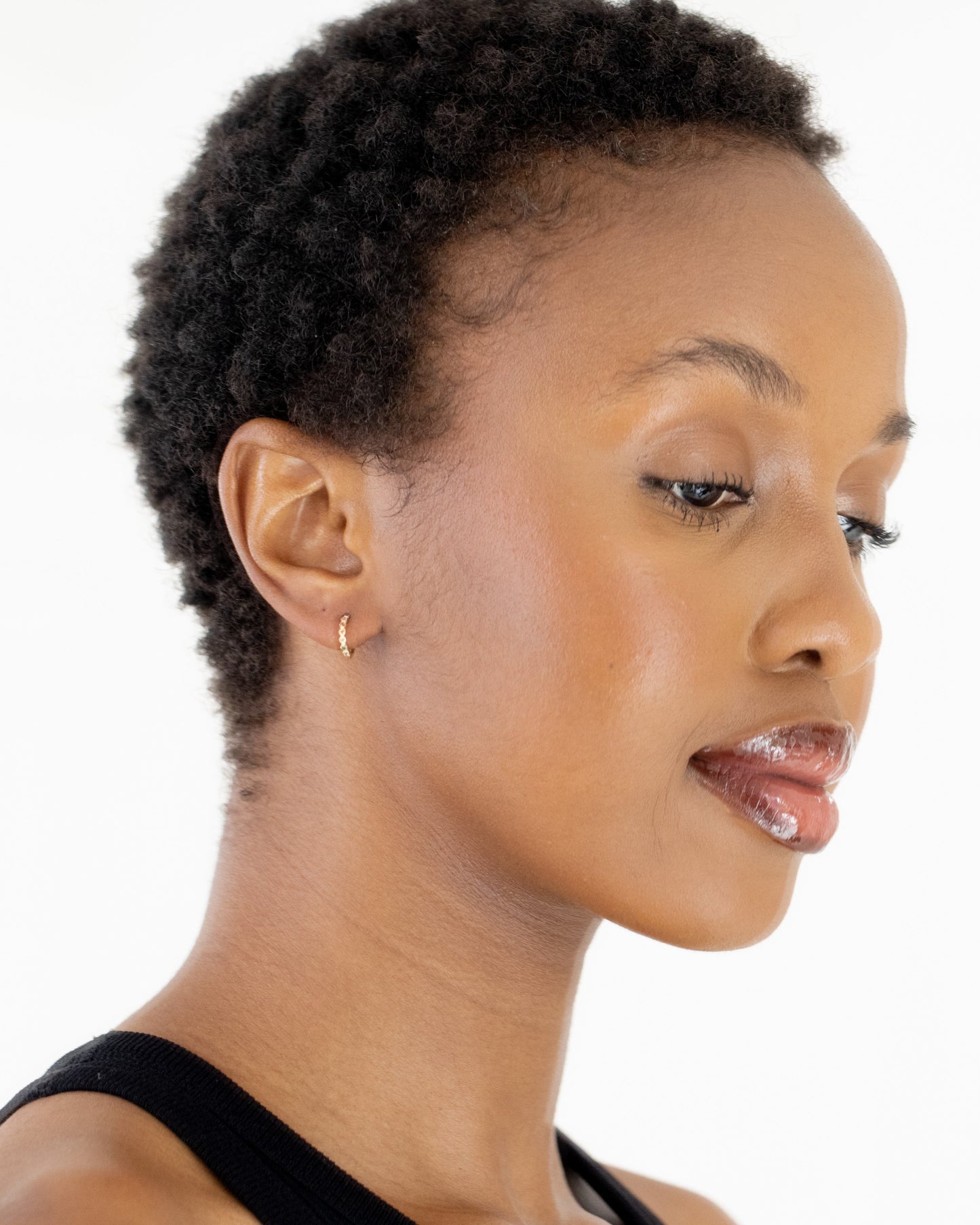 9kt gold Rainbow Huggie Earrings on model