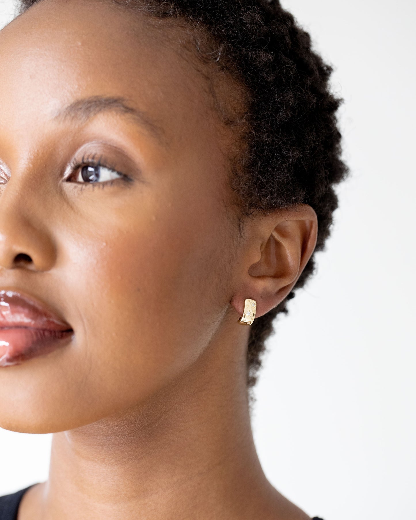 Gold hoop earrings on brown skinned model