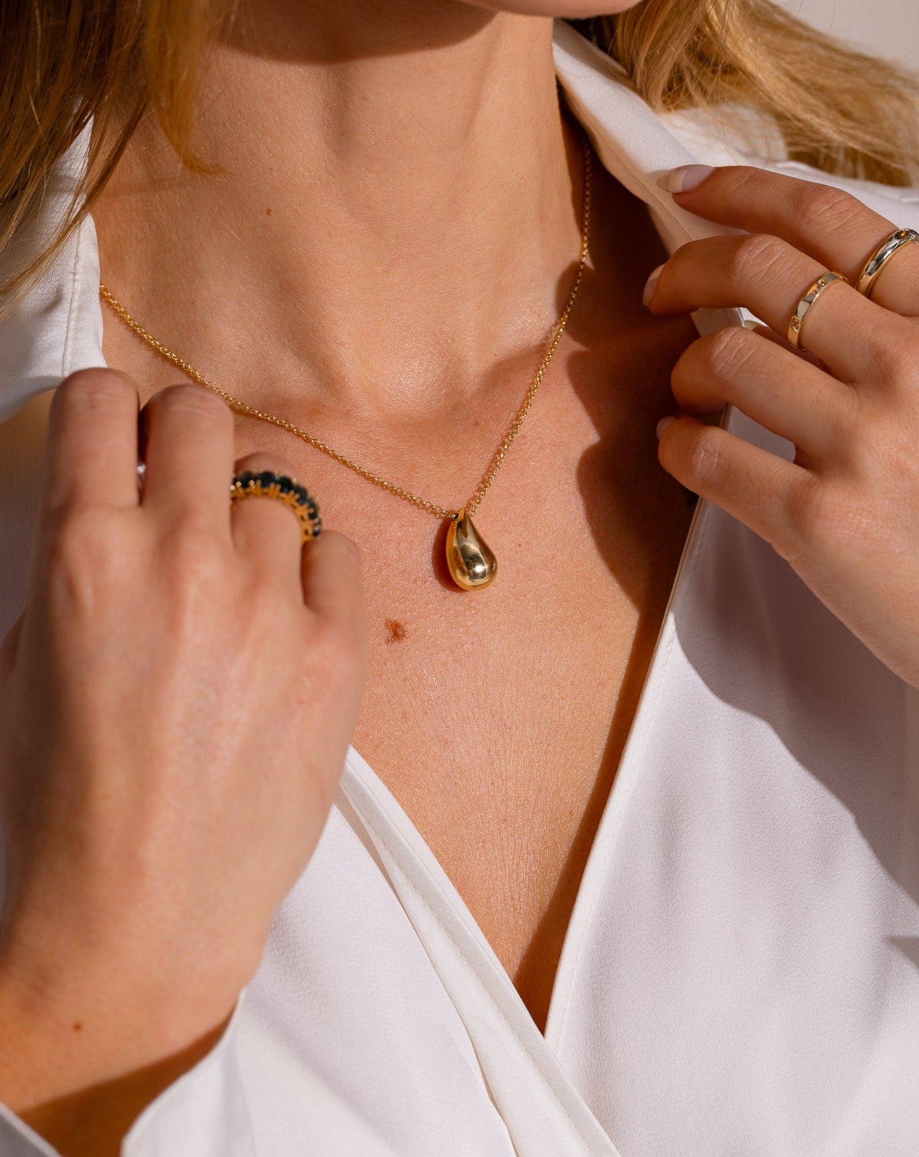 Gold teardrop pendant on female neck