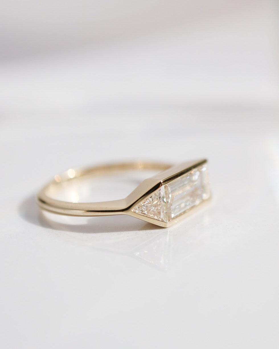 Gold ring with a diamond-shaped design on a light gray background