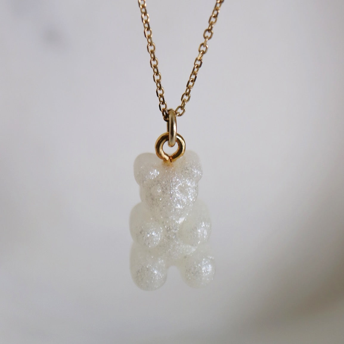 White gummy bear on gold jumpring