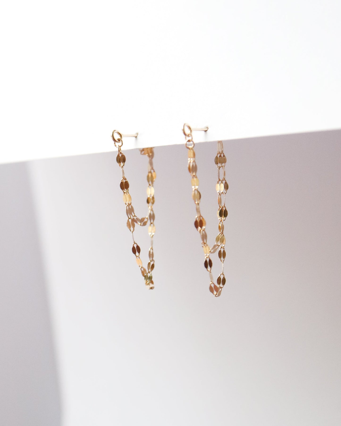 Gold chain necklace on a white surface