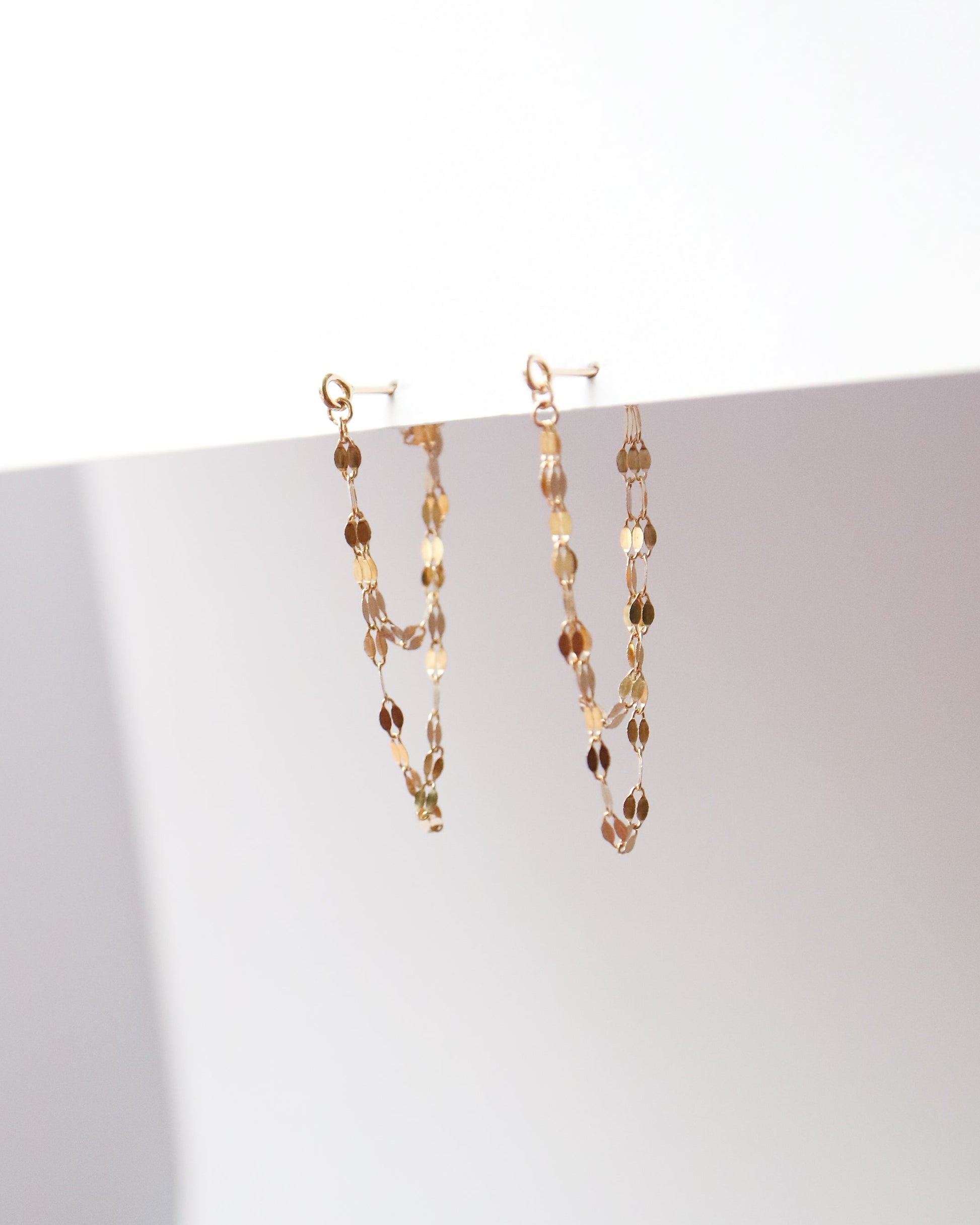 Gold chain necklace on a white surface