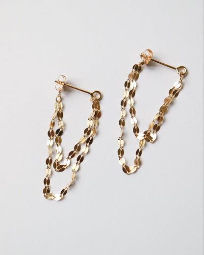 Gold chain hoop earrings on a light gray background