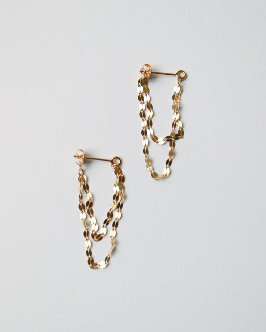 Pair of gold chain earrings on a light gray background