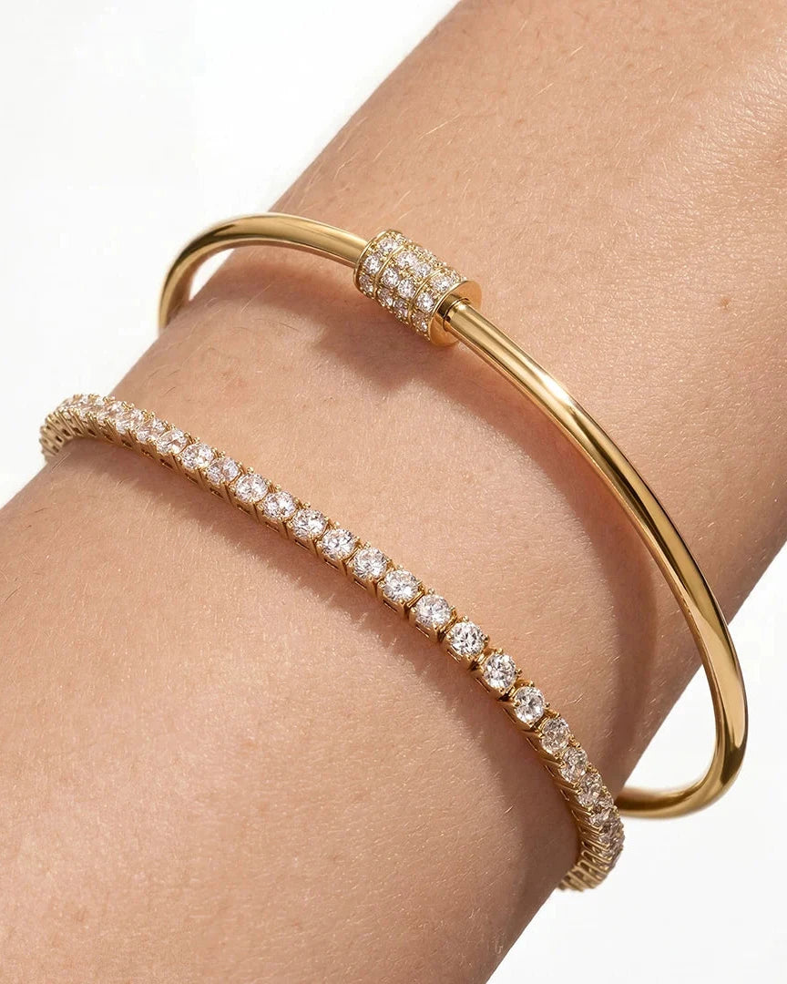 Gold bracelet with diamond accents on a wrist against a white background