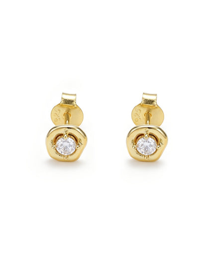 A pair of yellow gold stud earrings with a round bezel-set clear gemstone, shown against a plain white background.