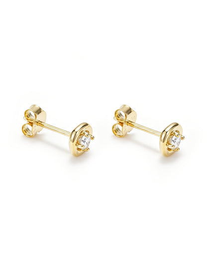 A pair of gold stud earrings with a circular bezel setting holding a clear round gemstone, shown on a clean white background.