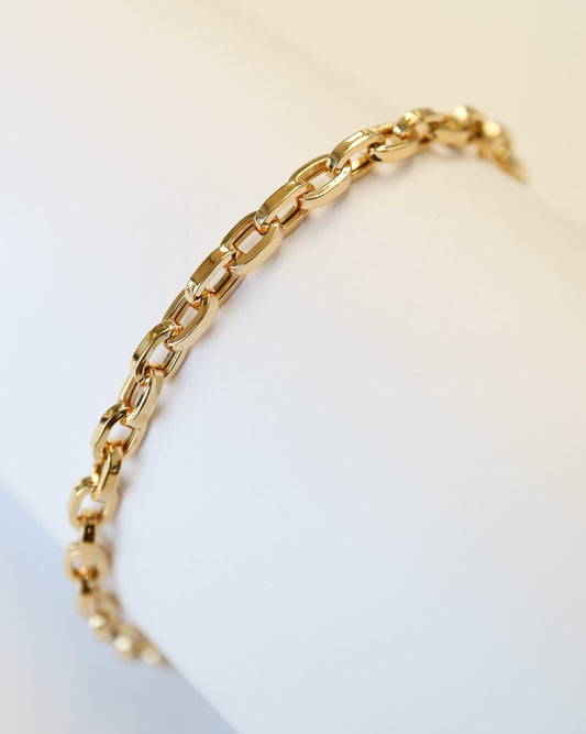 9kt solid gold Paperclip Cable Bracelet worn on the wrist, featuring polished elongated links and a modern gold chain design.