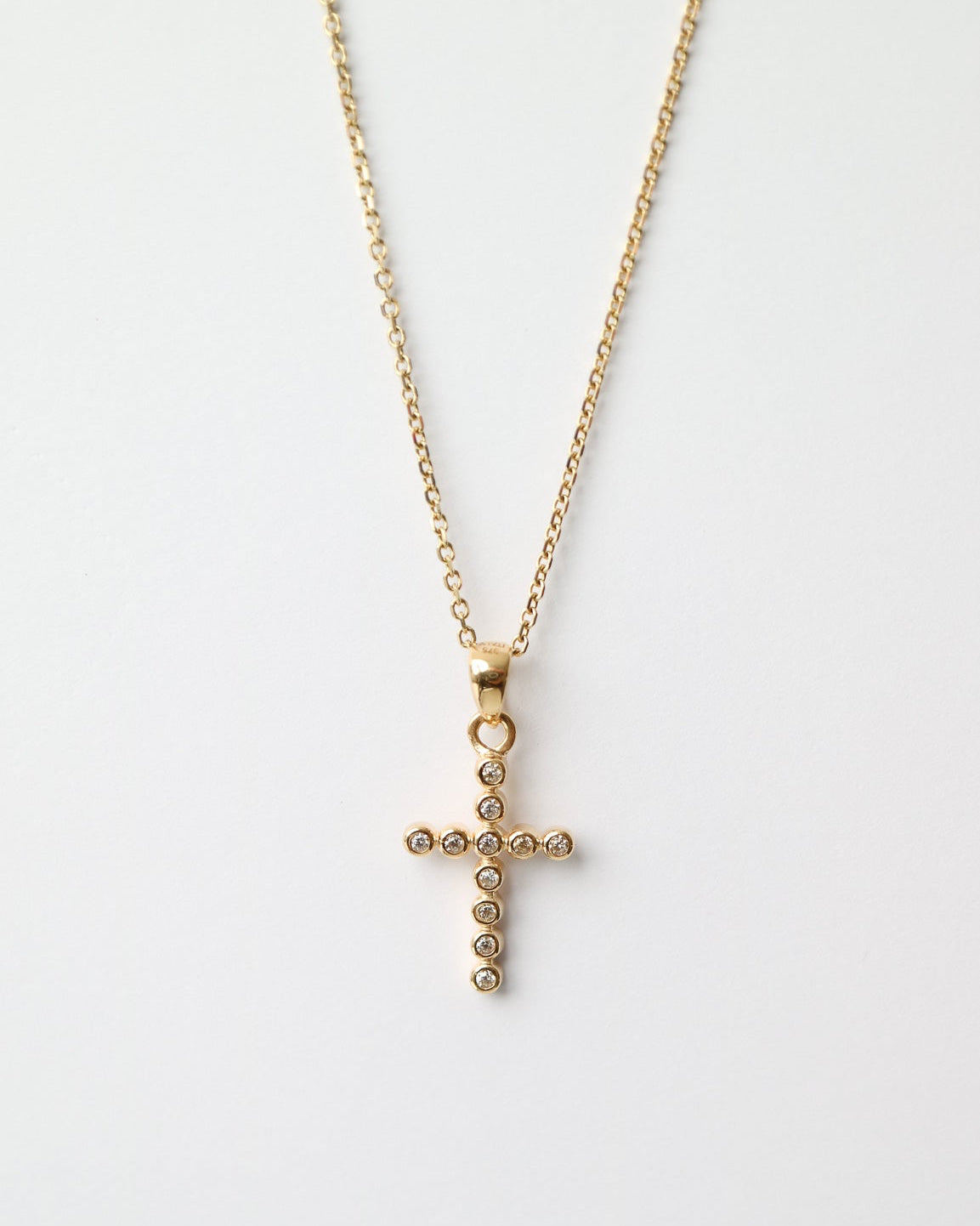 Gold cross necklace on a white background