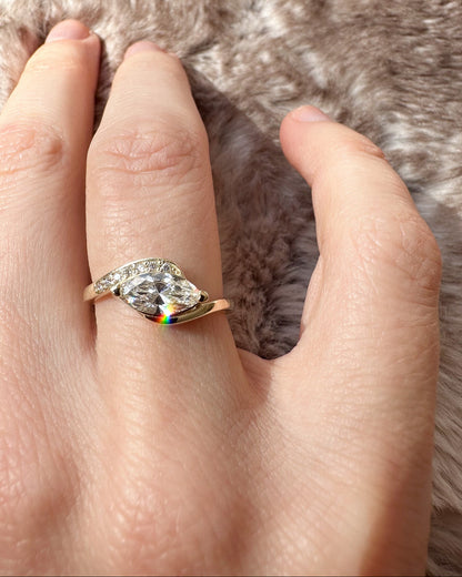 Hand wearing a ring with a large diamond on a fur background