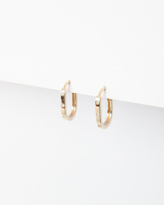 Gold hoop earrings on a white surface