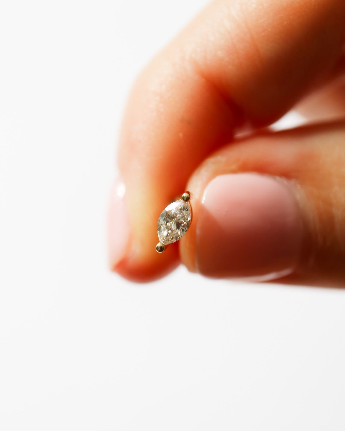 9ct gold diamond stud in human fingers for size reference