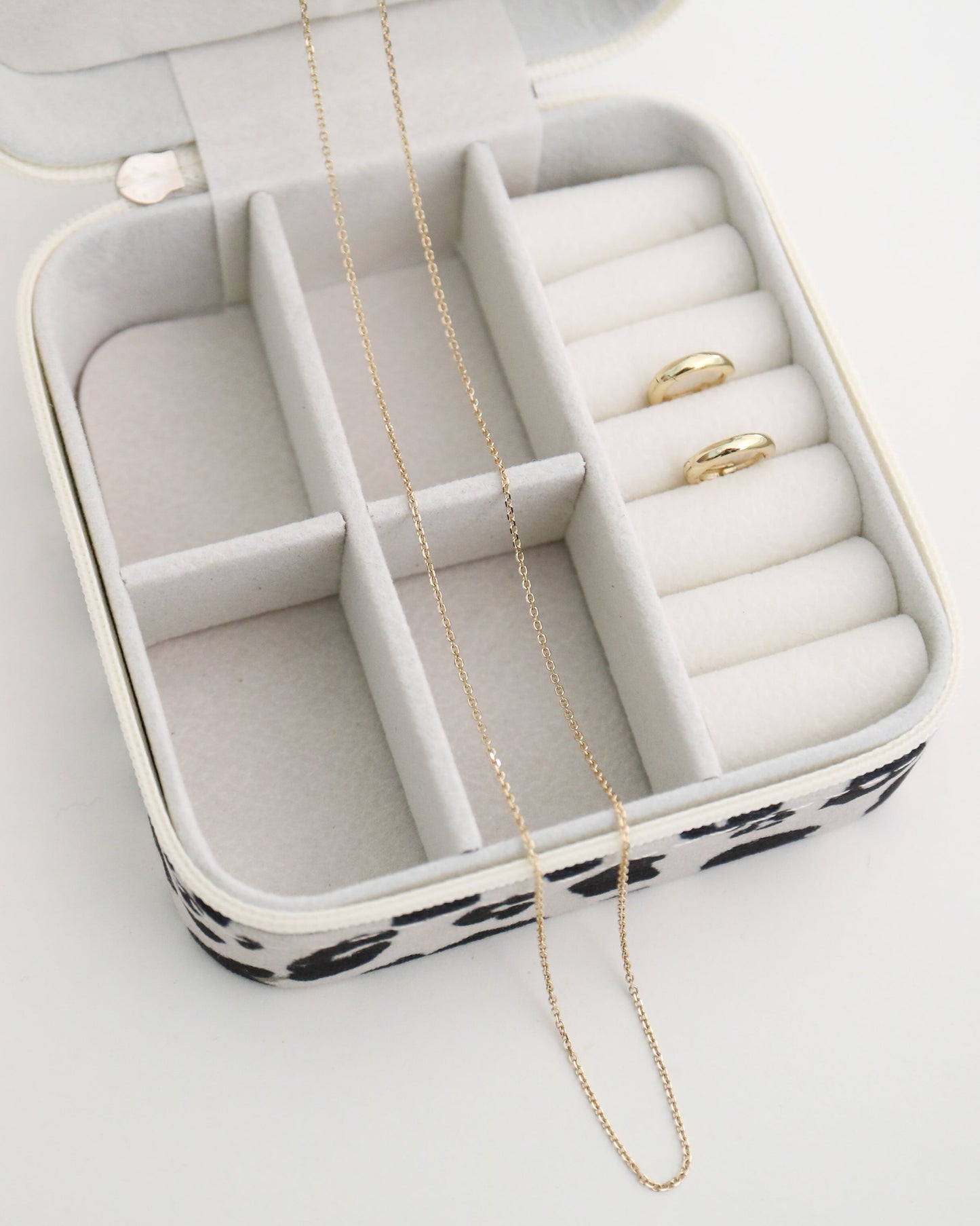 Jewelry box with gold necklace and earrings on a white background