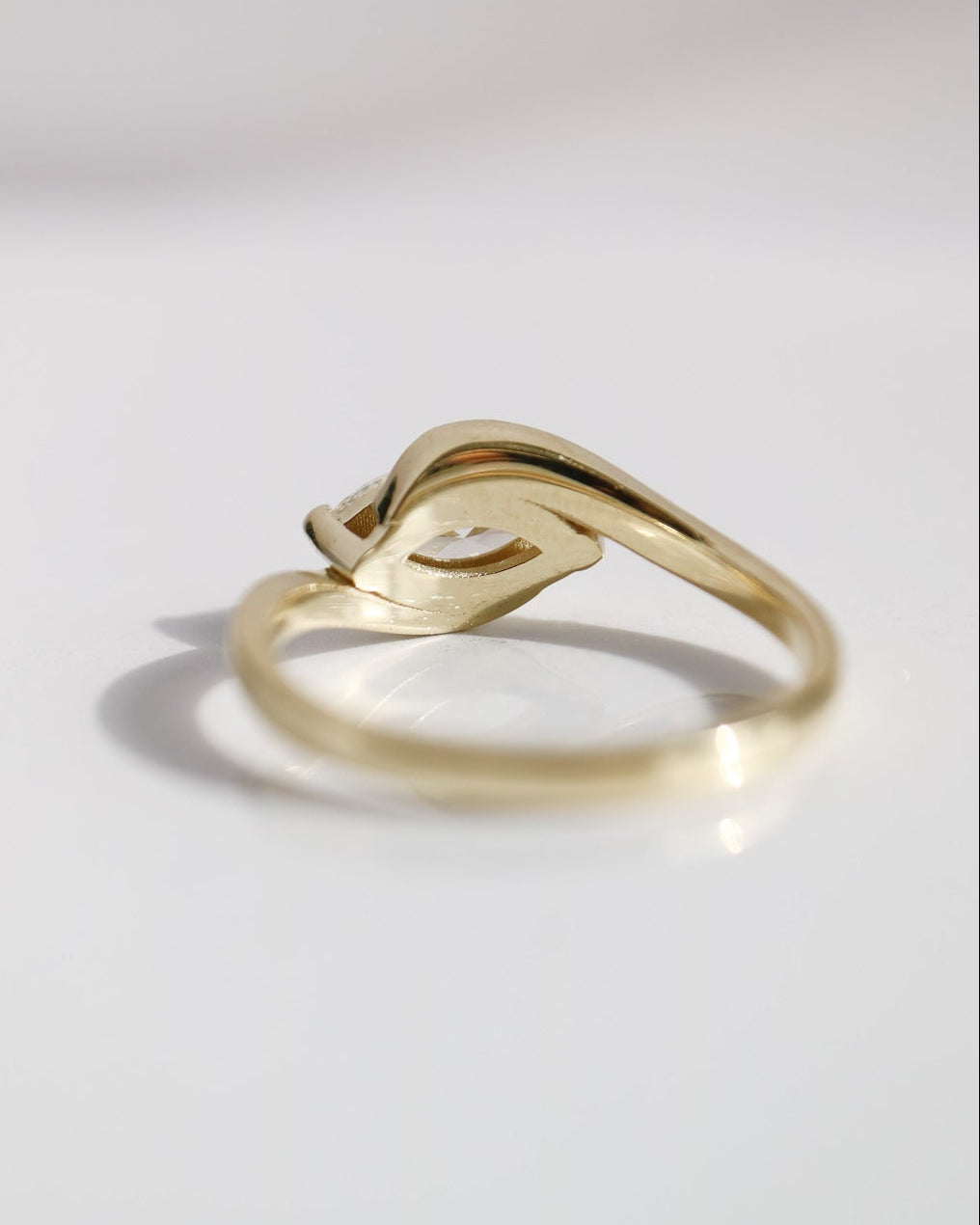 Gold ring with a unique design on a light gray background