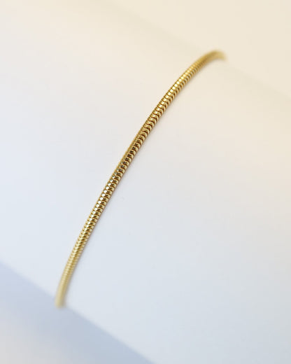 9kt gold snake chain bracelet on white tube background