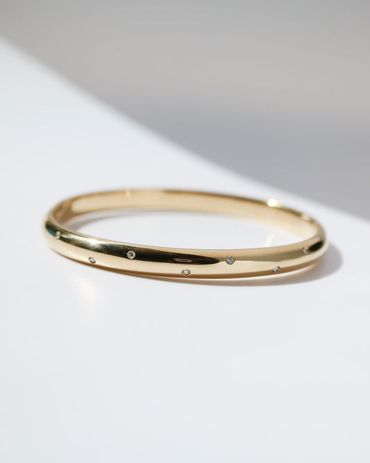 9kt yellow gold bangle with scattered lab-grown diamonds and a polished finish on a white background.