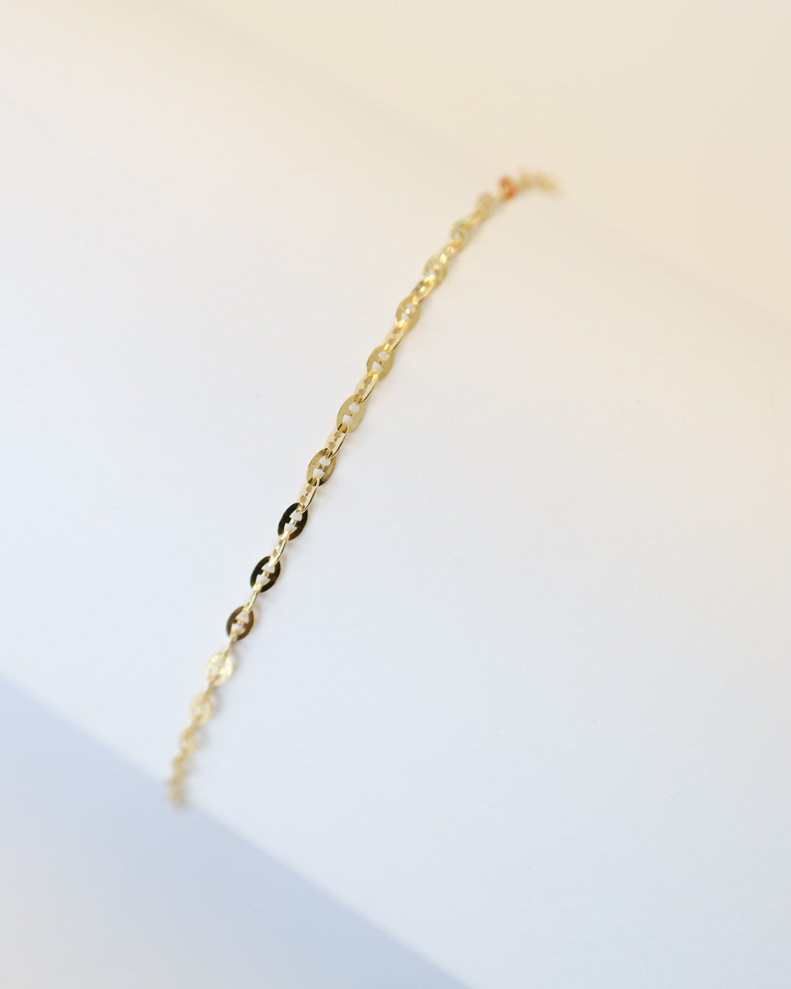 9ct solid gold Mini Gucci Link Chain bracelet on a white background, showcasing its delicate interlocking links and polished gold finish.