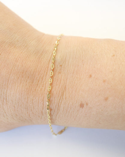 9ct solid gold Mini Gucci Link Chain bracelet on a female wrist on white background, showcasing its delicate interlocking links and polished gold finish.