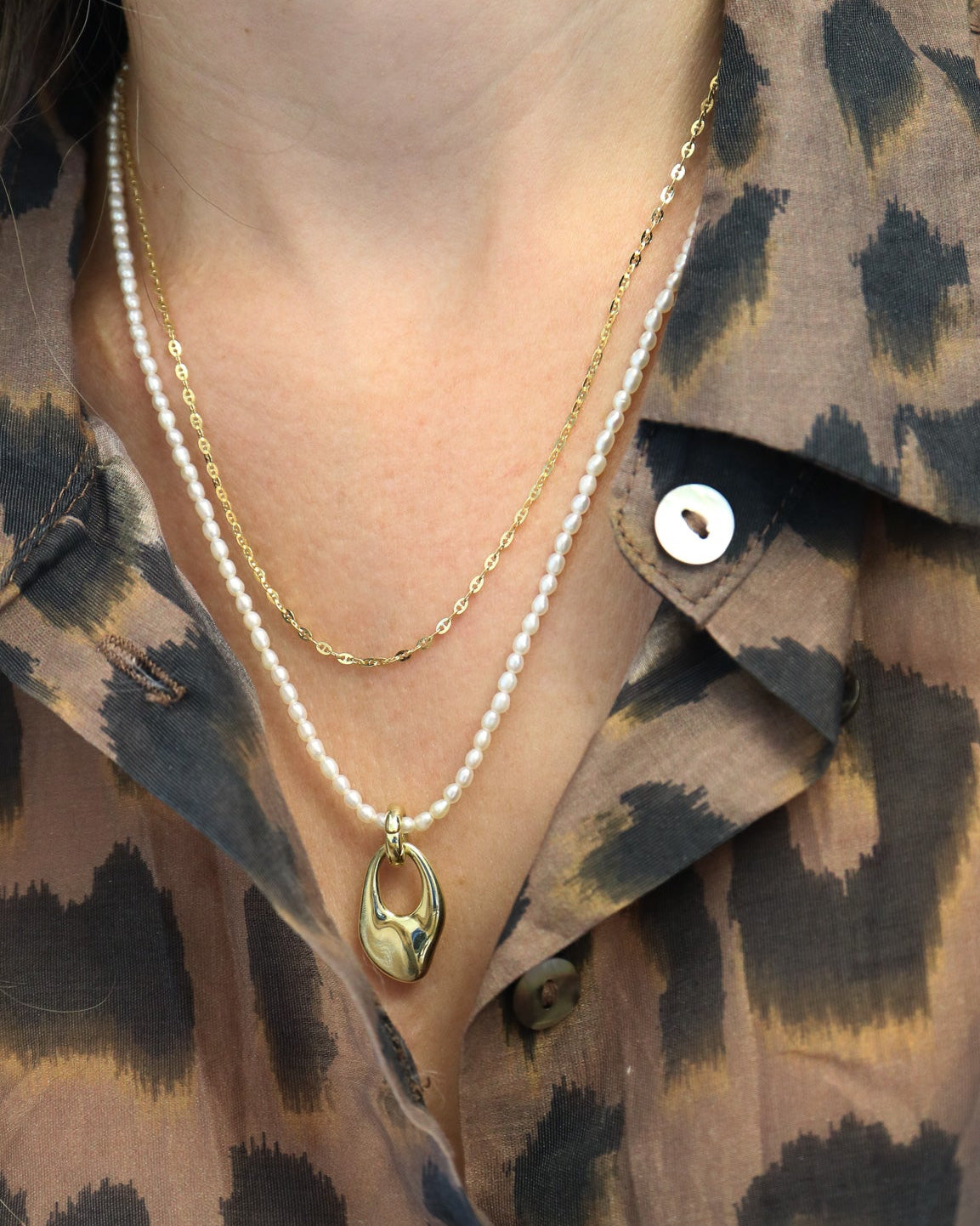 
9ct solid gold Mini Gucci Link Chain necklace on a white background, showcasing its delicate interlocking links and polished gold finish layered with pearl and gold pendant