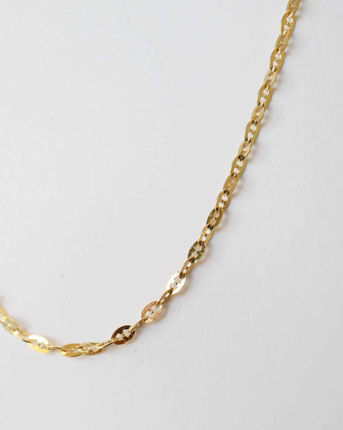 
9ct solid gold Mini Gucci Link Chain necklace on a white background, showcasing its delicate interlocking links and polished gold finish close up of links