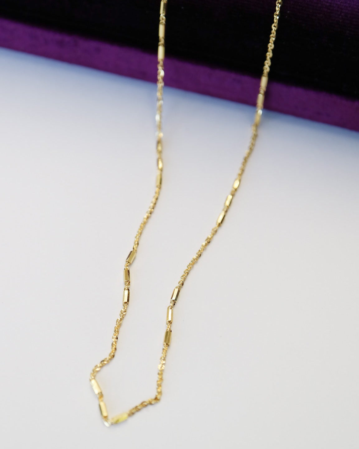 9kt solid gold Morse Code Chain necklace featuring a delicate gold chain with polished rectangular bar accents, photographed close up