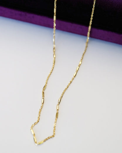 9kt solid gold Morse Code Chain necklace featuring a delicate gold chain with polished rectangular bar accents, photographed close up