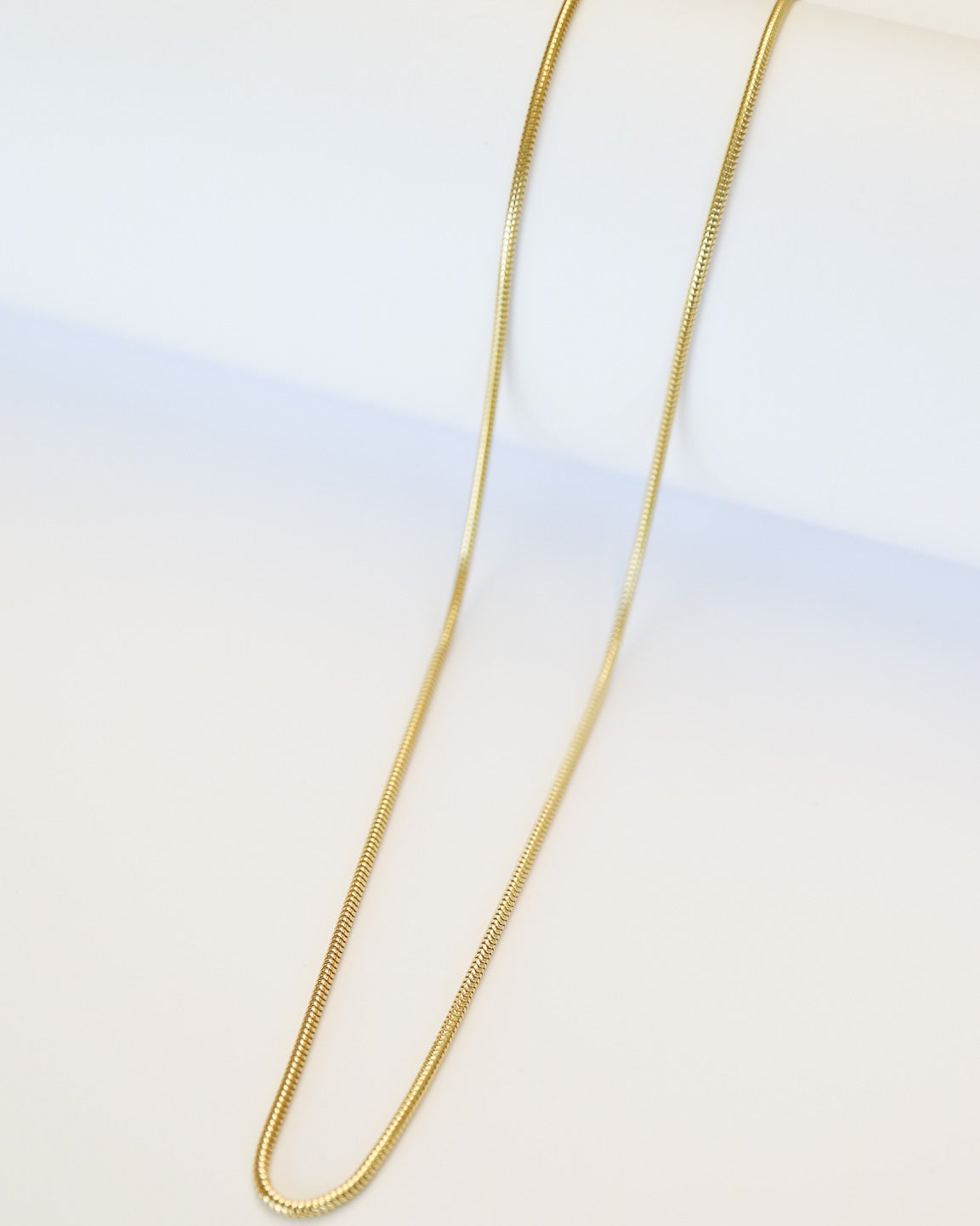 9ct gold Skinny Real Snake Chain over white background