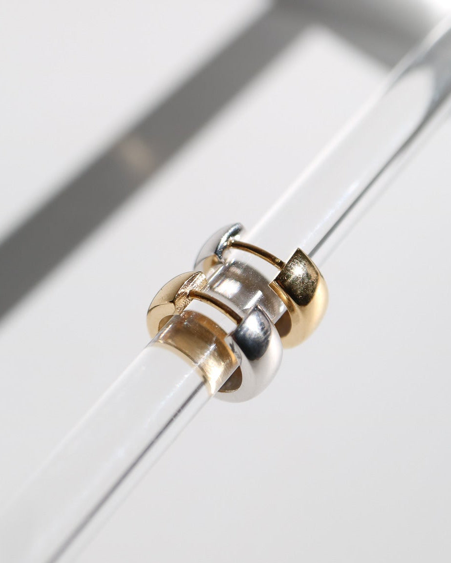 9kt solid gold Two Tone Hoops featuring a contemporary rounded design with contrasting polished gold and silver tones, photographed on a white background with soft sunlight and shadows.