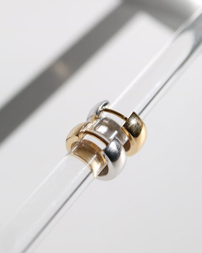 9kt solid gold Two Tone Hoops featuring a contemporary rounded design with contrasting polished gold and silver tones, photographed on a white background with soft sunlight and shadows.