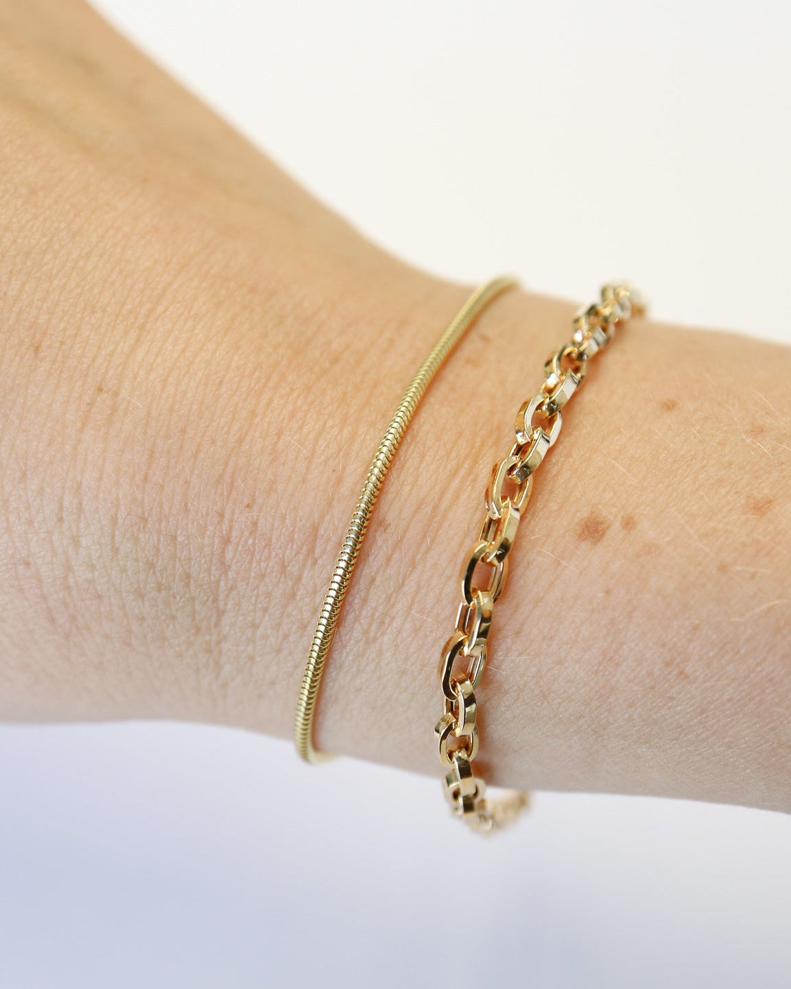 9kt solid gold Paperclip Cable Bracelet worn on the wrist, featuring polished elongated links and a modern gold chain design.