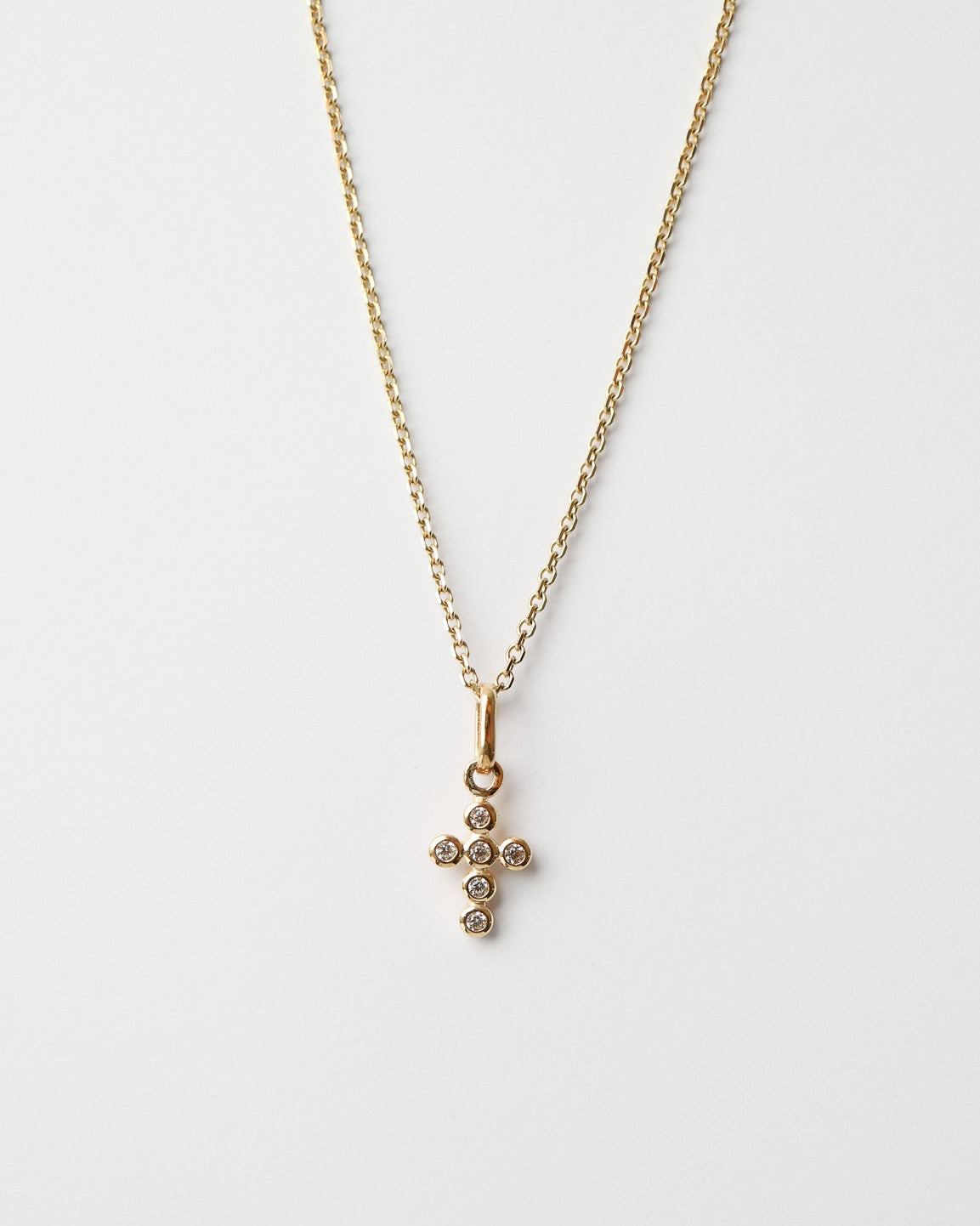 Gold necklace with a cross pendant on a white background