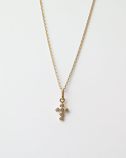Gold necklace with a cross pendant on a white background