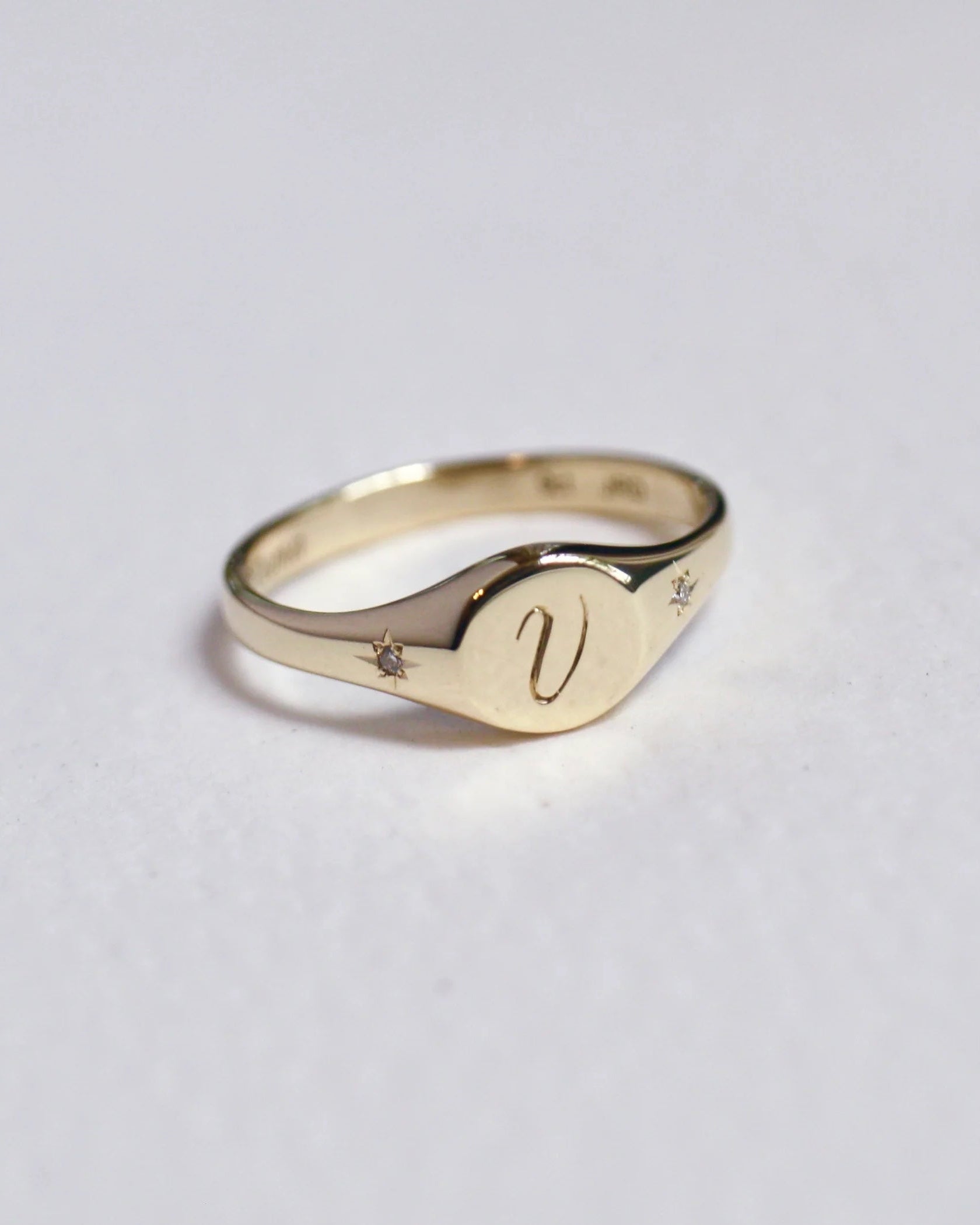 Gold ring with a diamond on a light gray background