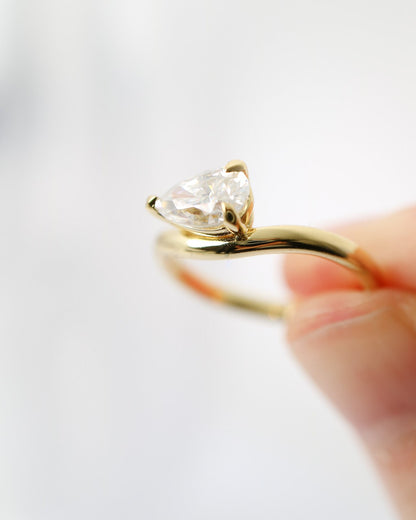 Gold ring with a heart-shaped diamond on a white background