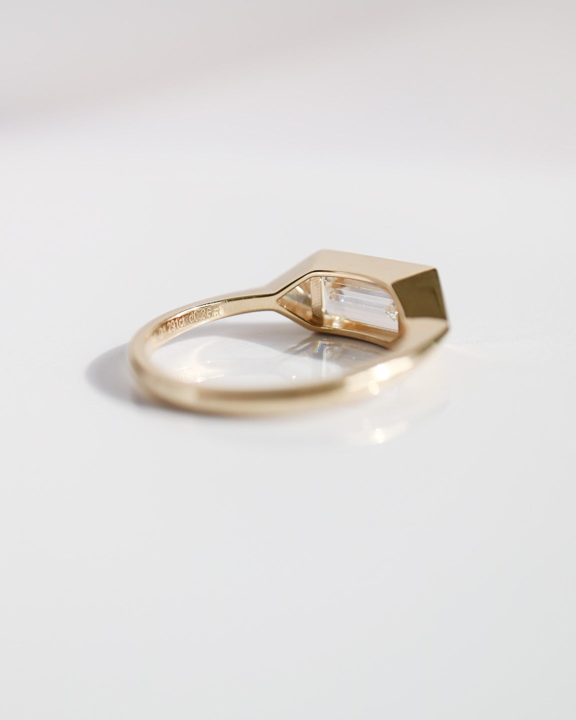 Gold ring with a geometric design on a light gray background