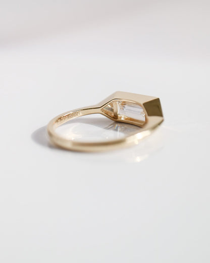 Gold ring with a geometric design on a light gray background
